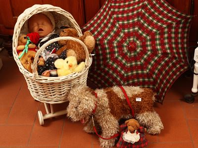 Assortimento di bambole e peluche, carrozzina in vimini, h 53 cm