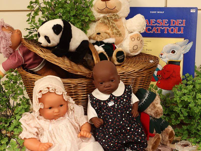Cesto di balocchi con bambole e peluche