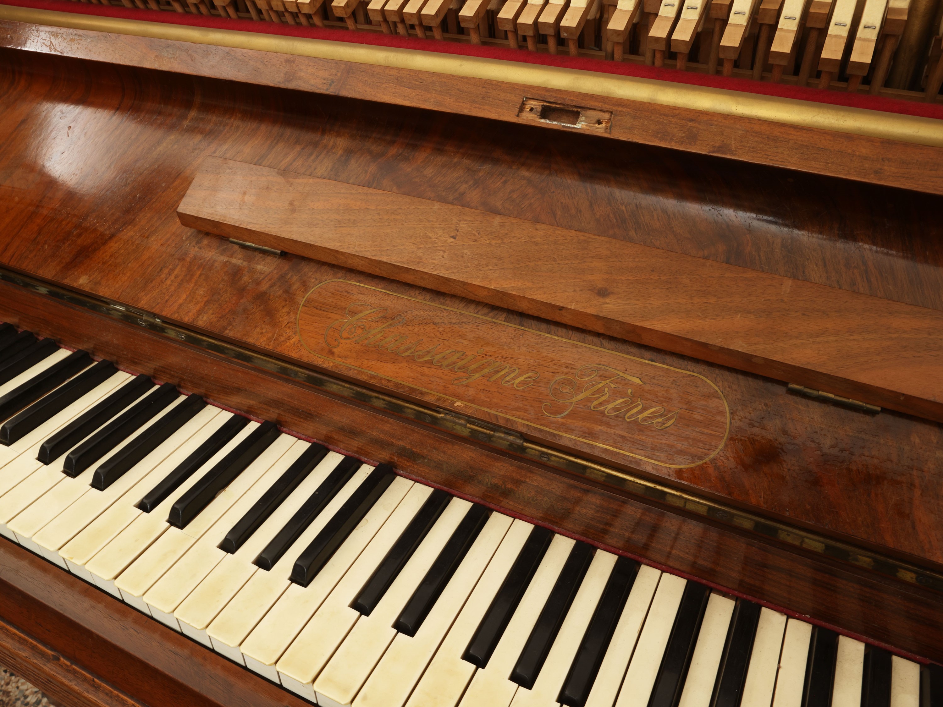 Pianoforte verticale, impiallacciato e intarsiato in noce e piuma di noce