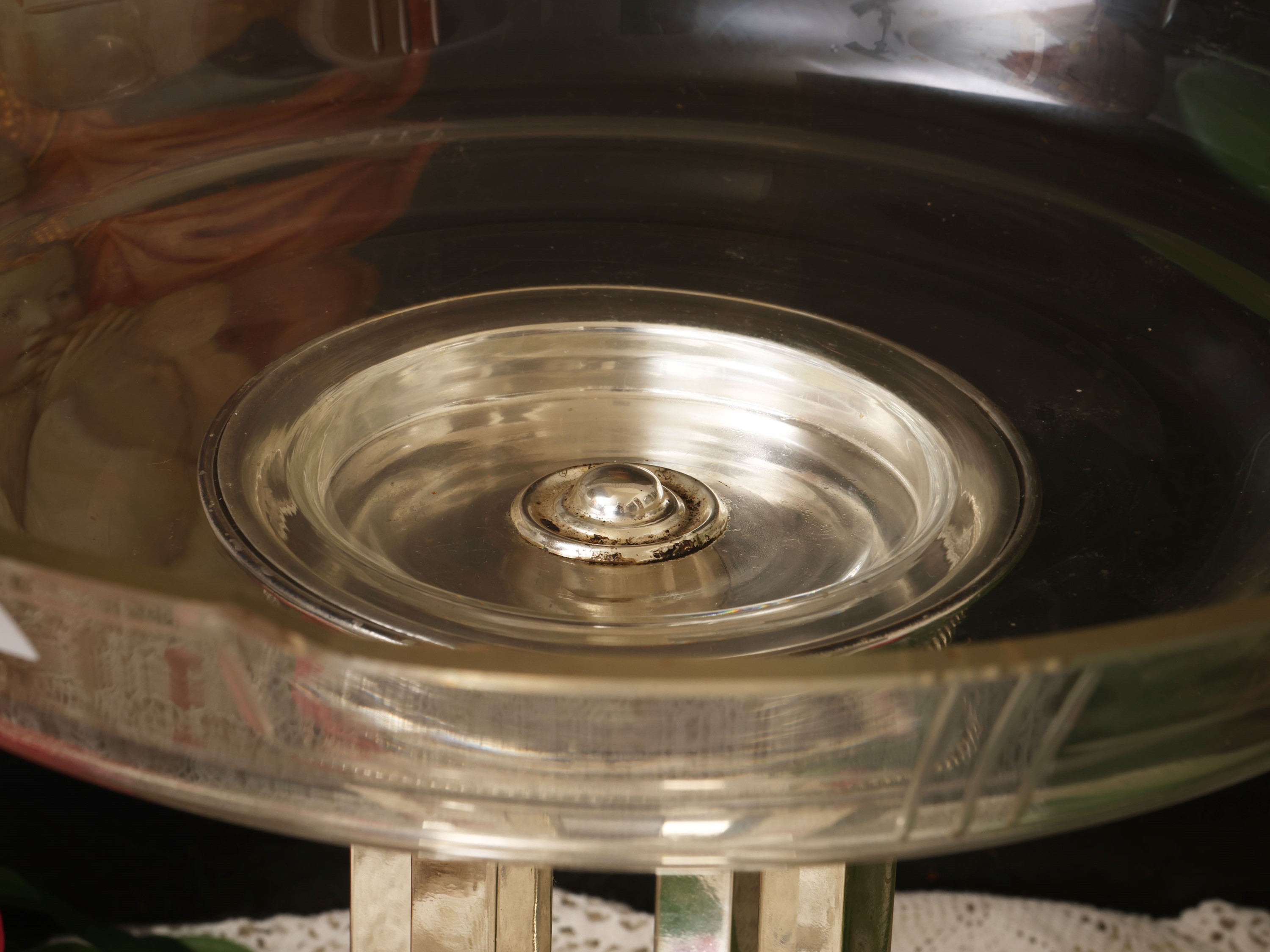 Grande alzata centrotavola in vetro, bordo sagomato e base a quattro colonne su plinto