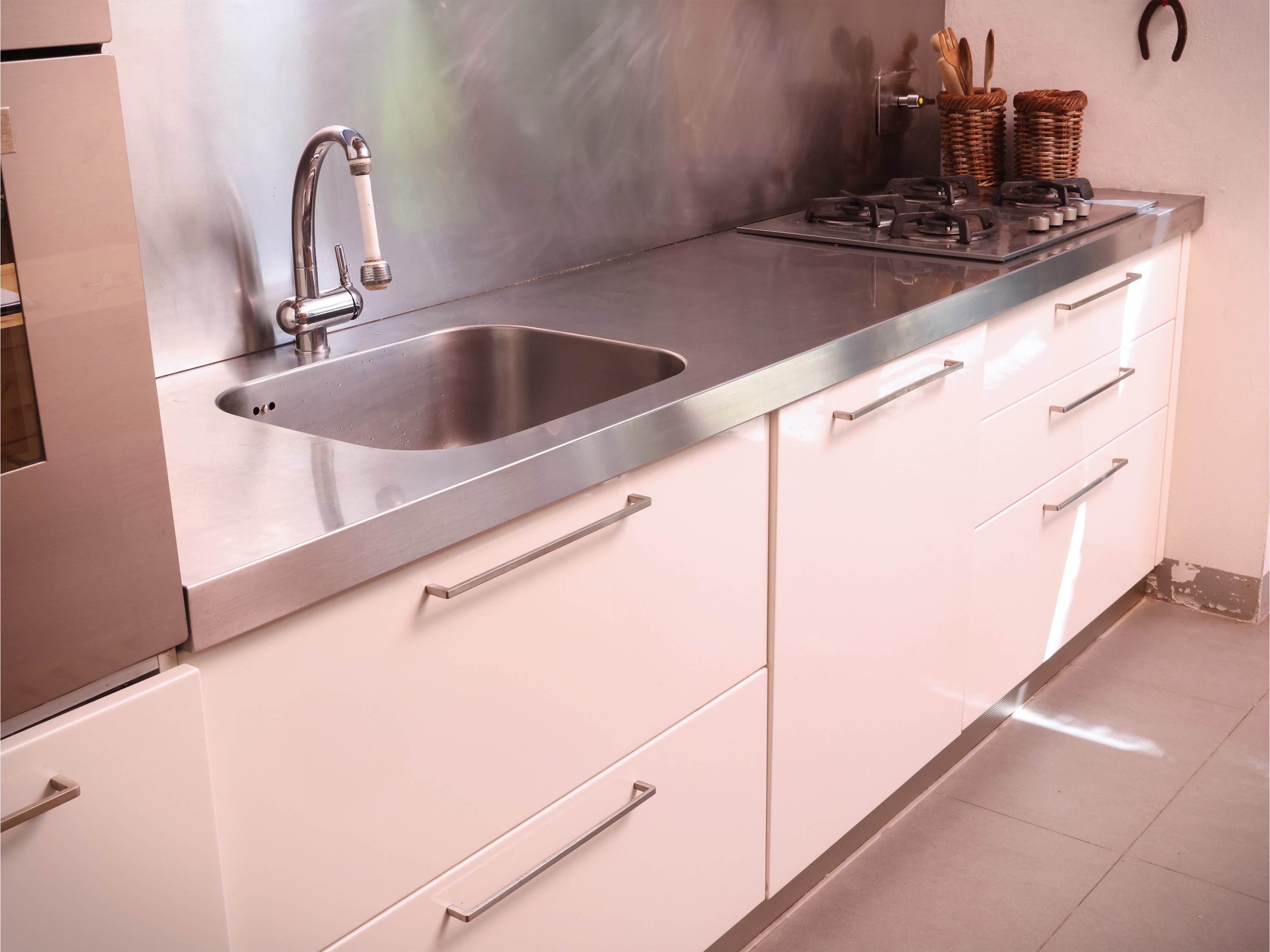 Cucina in laminato laccato bianco con piano e paraschizzi in acciaio inox
