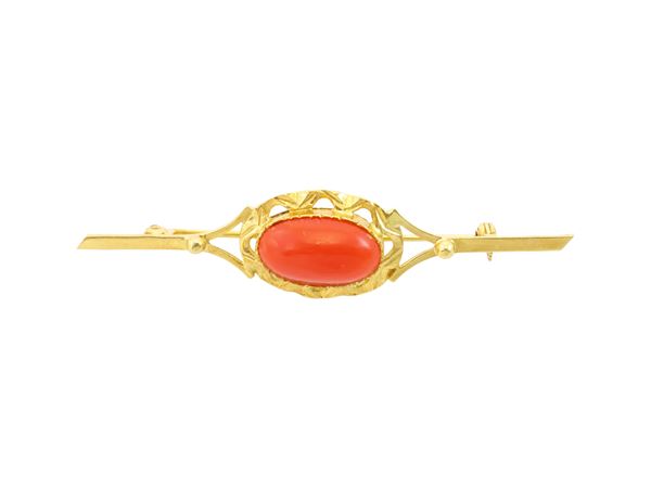 A 18k yellow gold brooch with cabochon coral