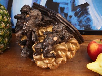 Mensola in legno ebanizzato e dorato, base intagliata con amorini (XIX secolo)