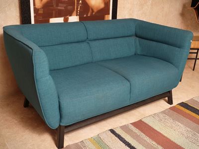 Natuzzi, Divano imbottito in tessuto color ottanio con dettagli in legno ebanizzato