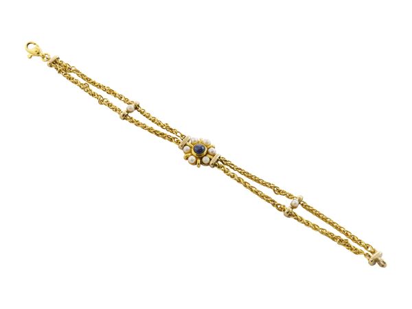 A 18K yellow gold bracelet with small white cultured pearls and cabochon sapphire