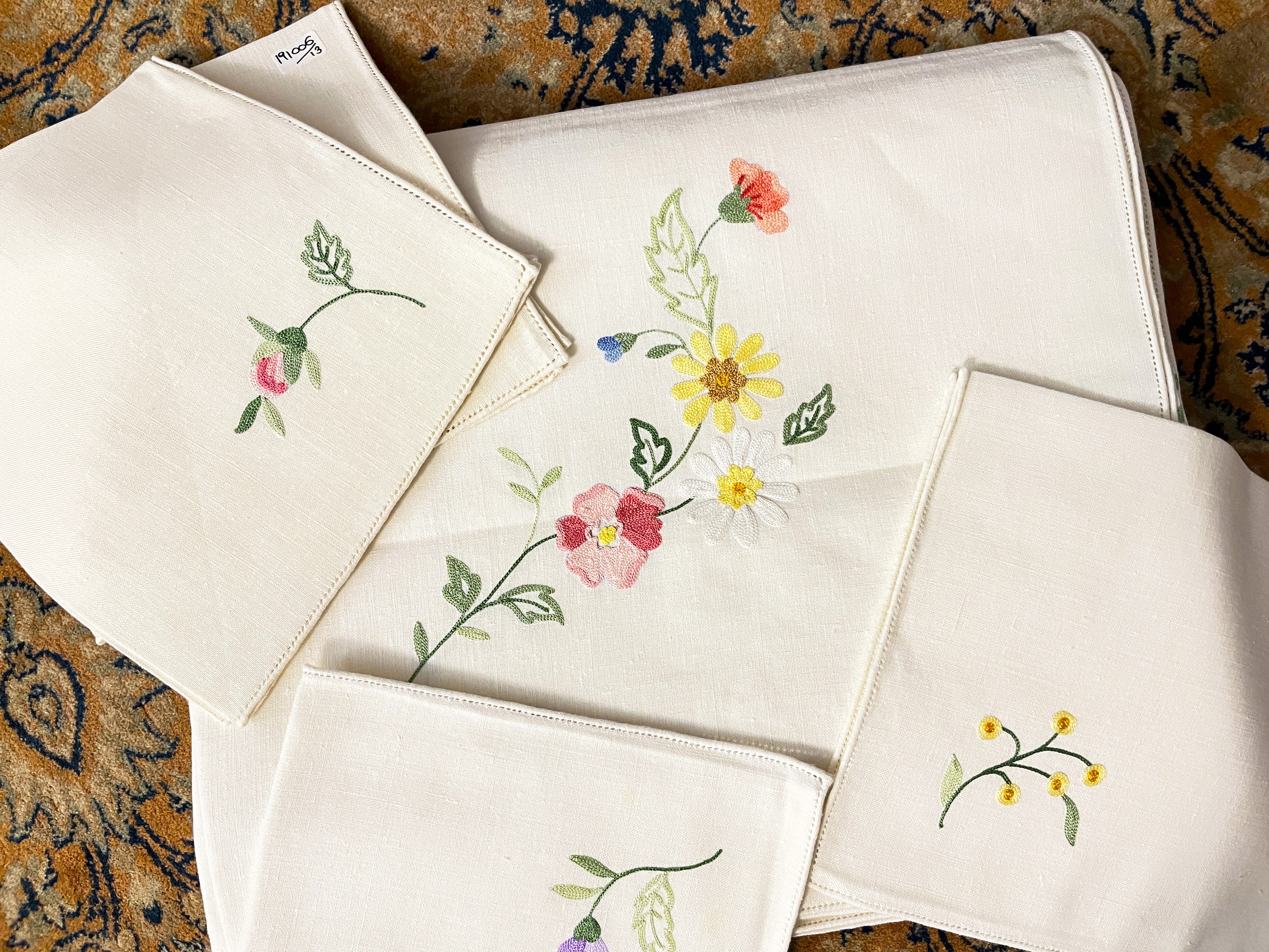 Tovaglia ricamata in lino bianco, punto pieno con fiori policromi e bordo a giorno