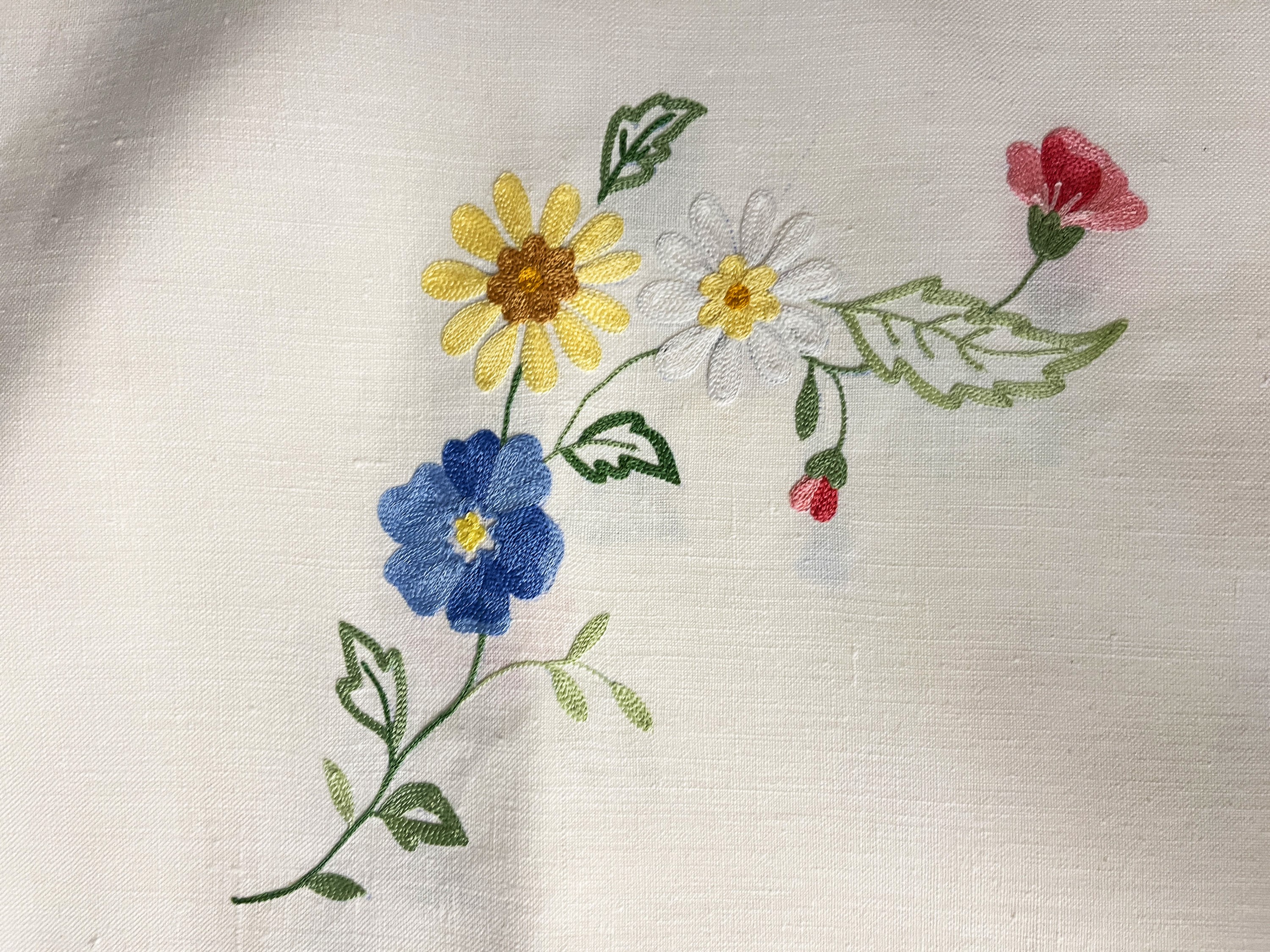 Tovaglia ricamata in lino bianco, punto pieno con fiori policromi e bordo a giorno