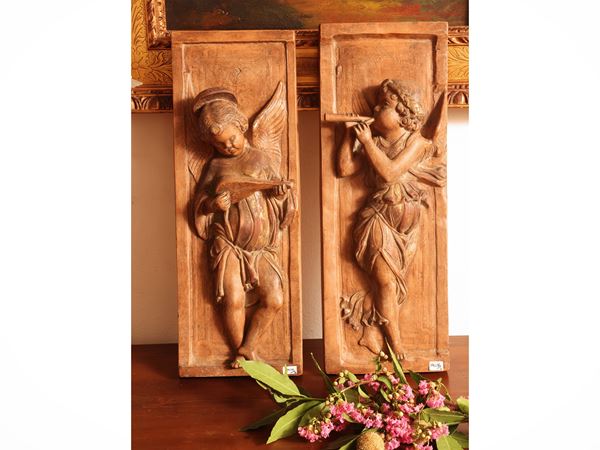 Coppia di fregi in terracotta patinata