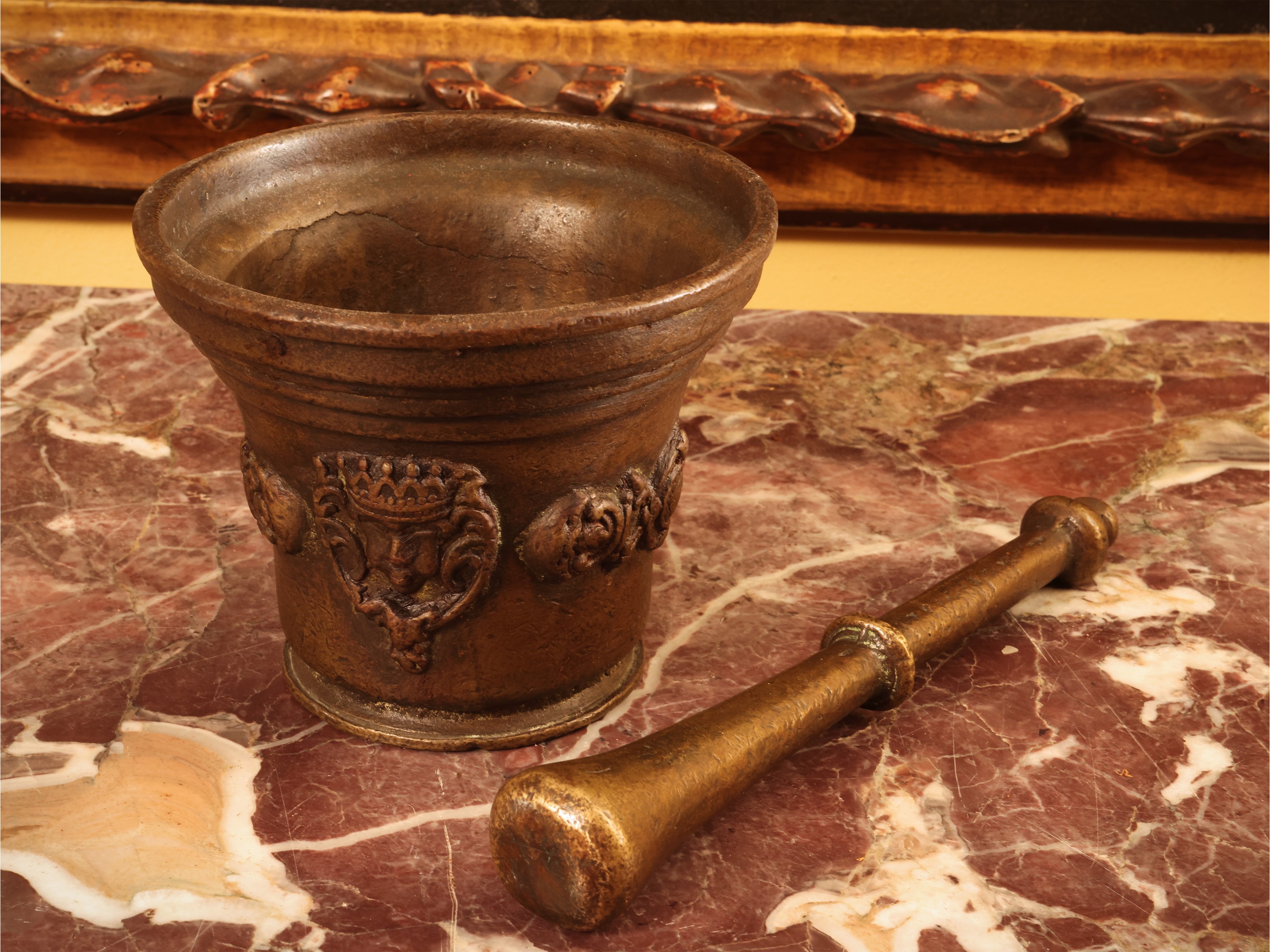 Mortaio in bronzo, sbalzato con mascheroni e prese laterali a ricciolo, con pestello