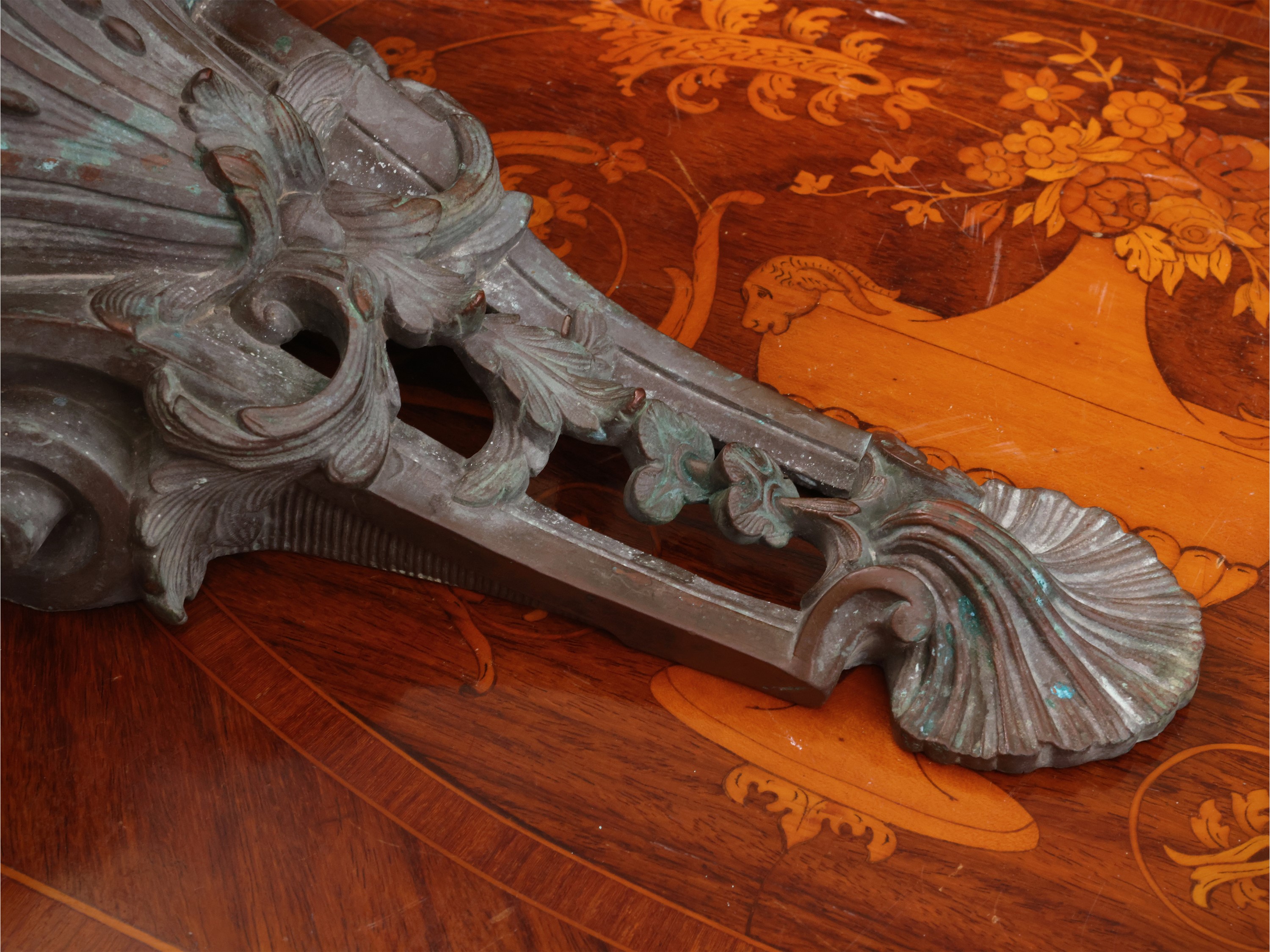 Piccola mensola in bronzo, bordo sagomato e decorazione a festone floreale