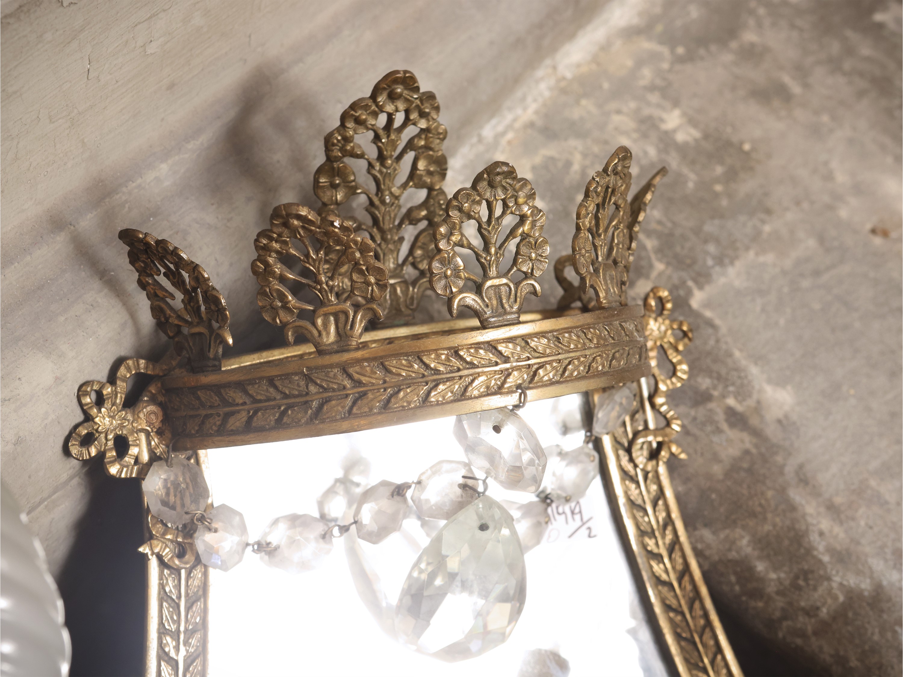 Coppia di ventole ornamentali in metallo dorato, sbalzate con amorini e palmette, con pendenti in...