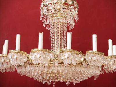 Lampadario a corolla, metallo dorato e cristallo molato, con sedici bracci portacandele