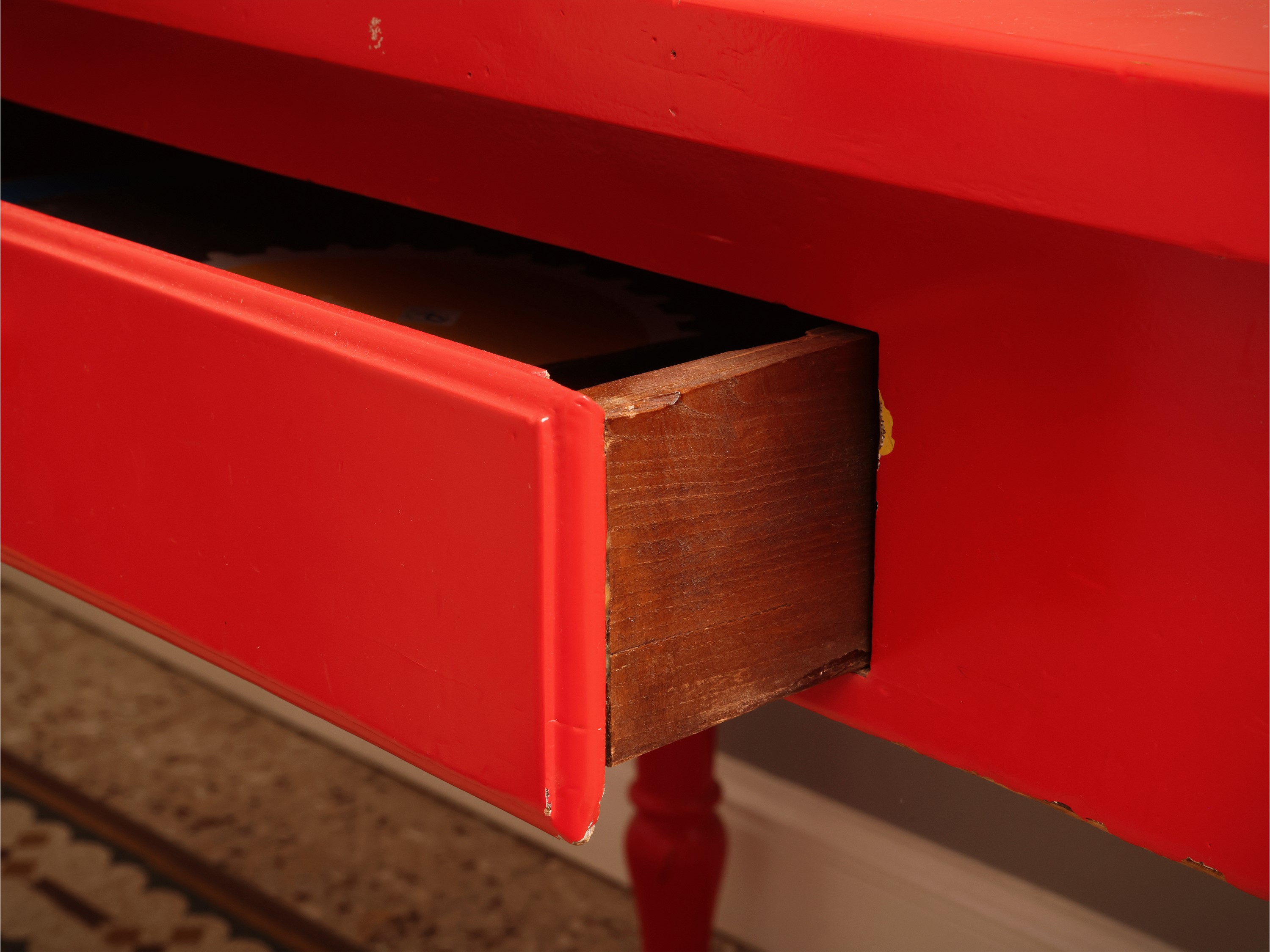 Tavolo in legno laccato rosso con cassetto sottopiano e gambe tornite