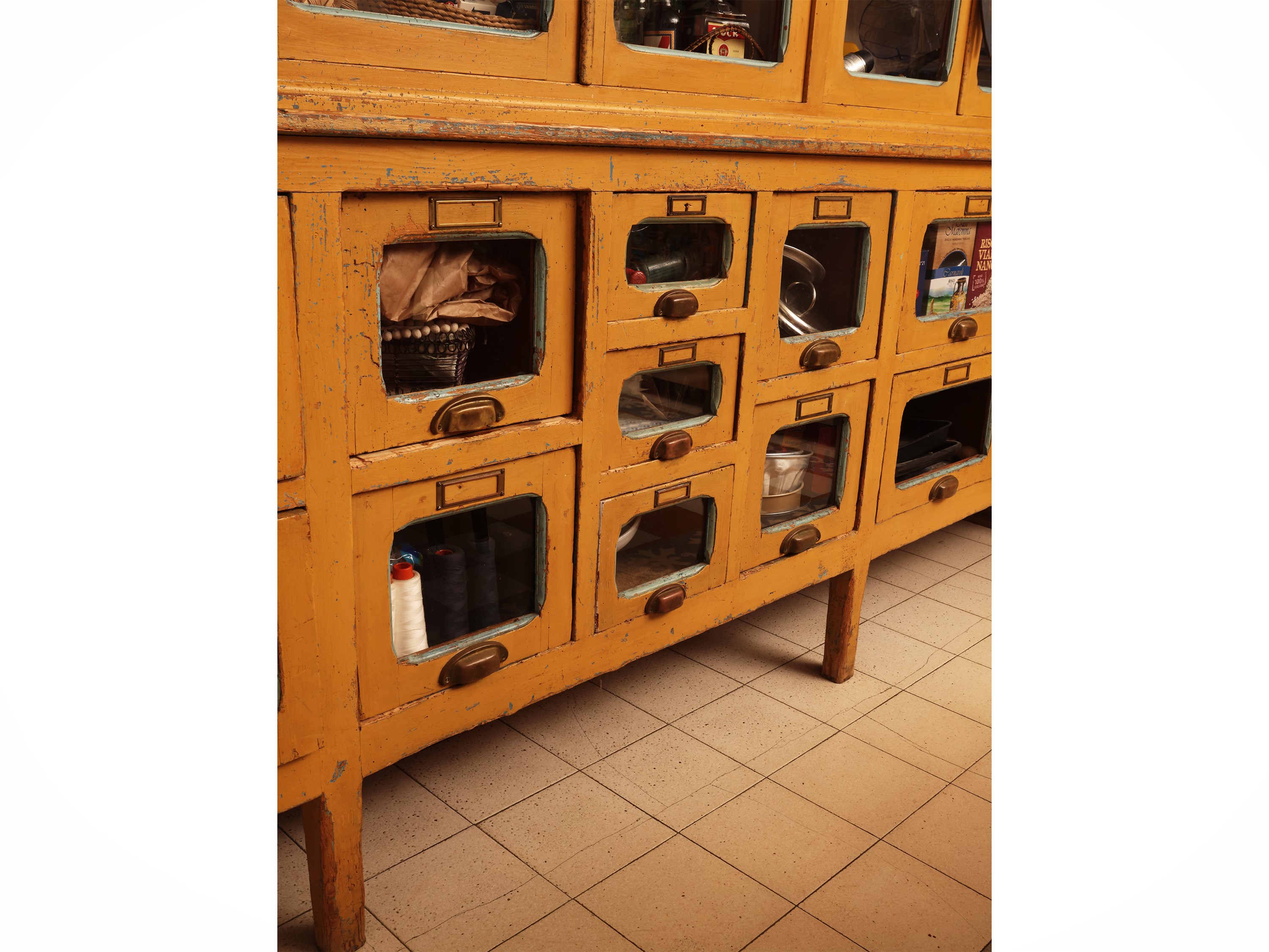 Grande mobile da farmacia in legno laccato giallo ocra, sportelli a vetro e cassetti, anni Quaran...