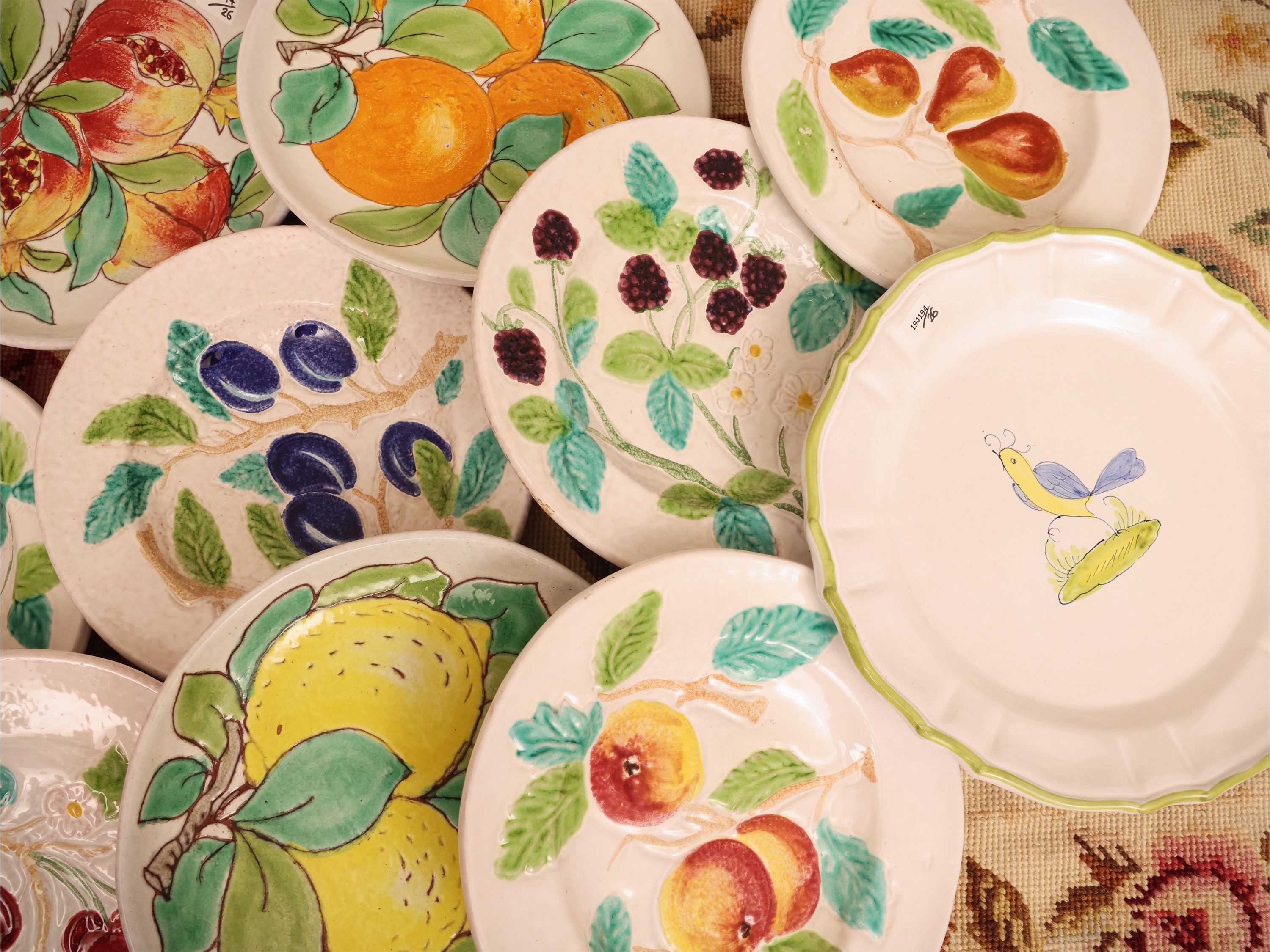 Miscellanea di piatti decorativi e da tavola in ceramica, composizione di 11 piattini con frutti ...