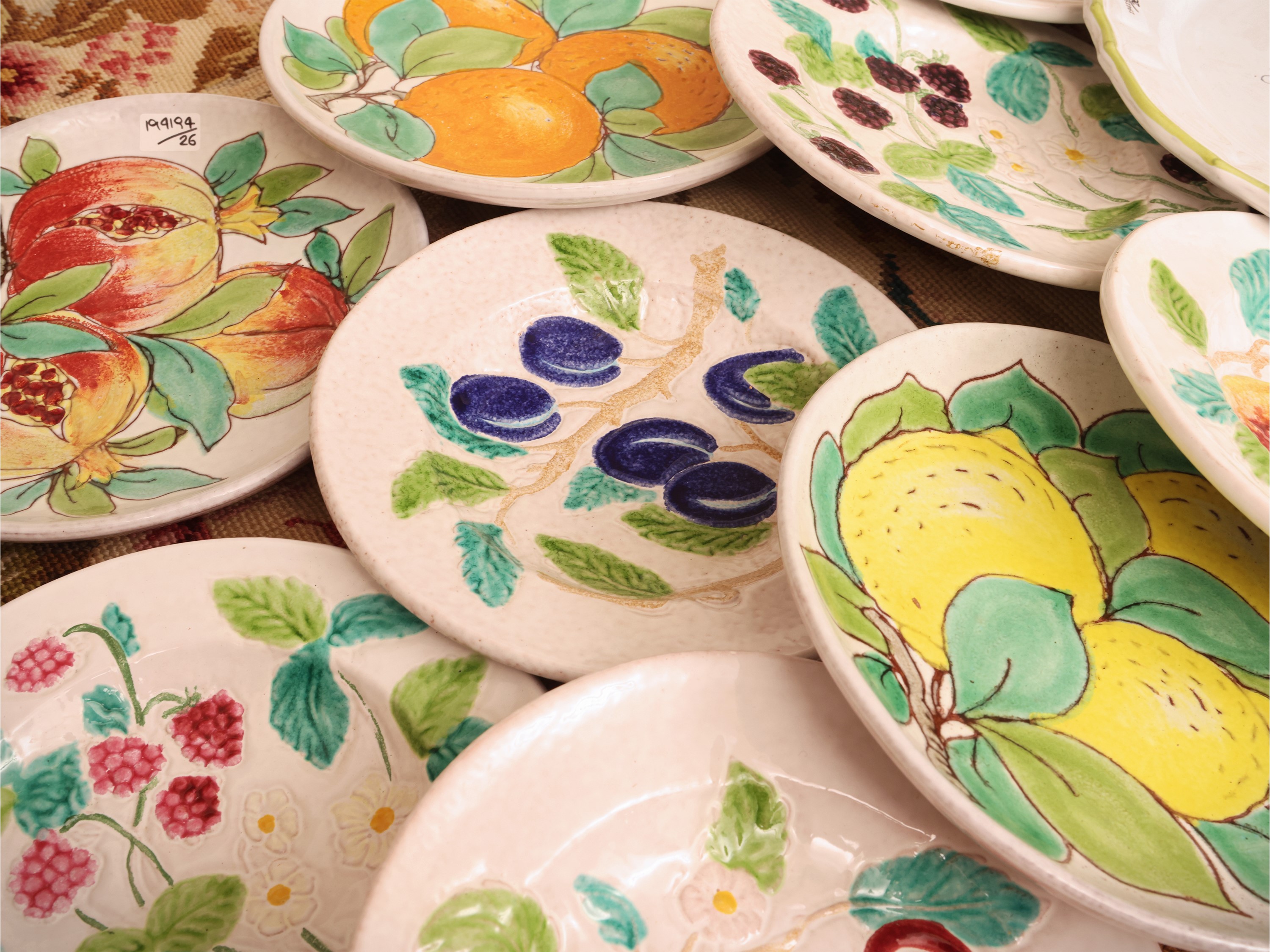 Miscellanea di piatti decorativi e da tavola in ceramica, composizione di 11 piattini con frutti ...