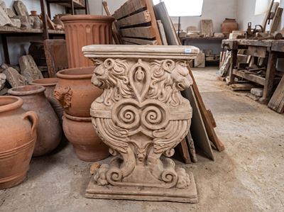 Sostegno in terracotta patinata decorato con leoni contrapposti