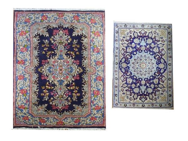 Due piccoli tappeti uno Kirman fondo blu con motivi floreali nei toni del rosa ed uno Nain