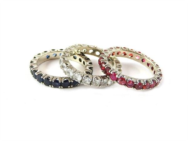 Three white gold rings with rubies, sapphires and colourless stones