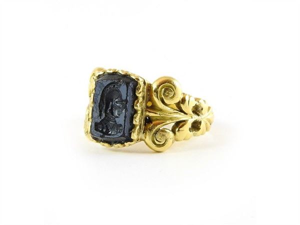 Yellow wrought gold ring with engraved stone