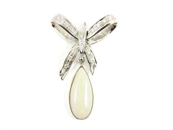White gold bow shaped pendant with diamond and pearshape opal