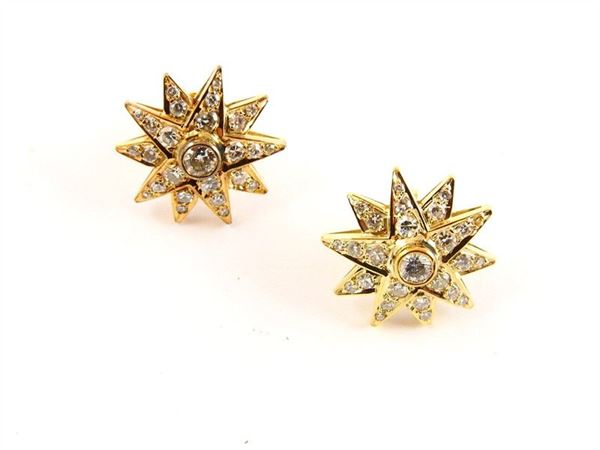 Yellow gold star shaped earclips with diamonds