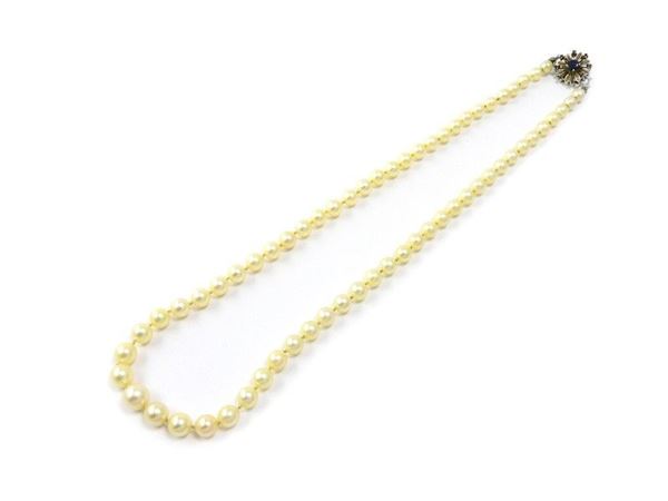 Graduated cultured pearls strand with white gold and sapphire clasp