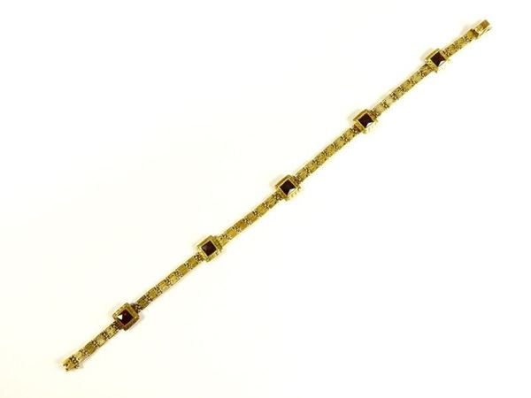 Yellow gold woven bracelet with garnets