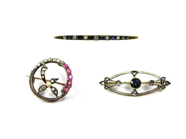 Three brooches in yellow and white gold, silver, sapphires, rubies and diamonds