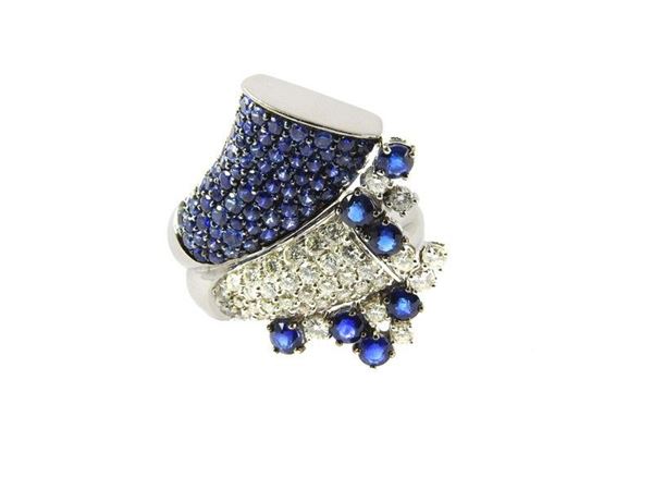 White gold cornucopia shaped ring set with diamonds and sapphires